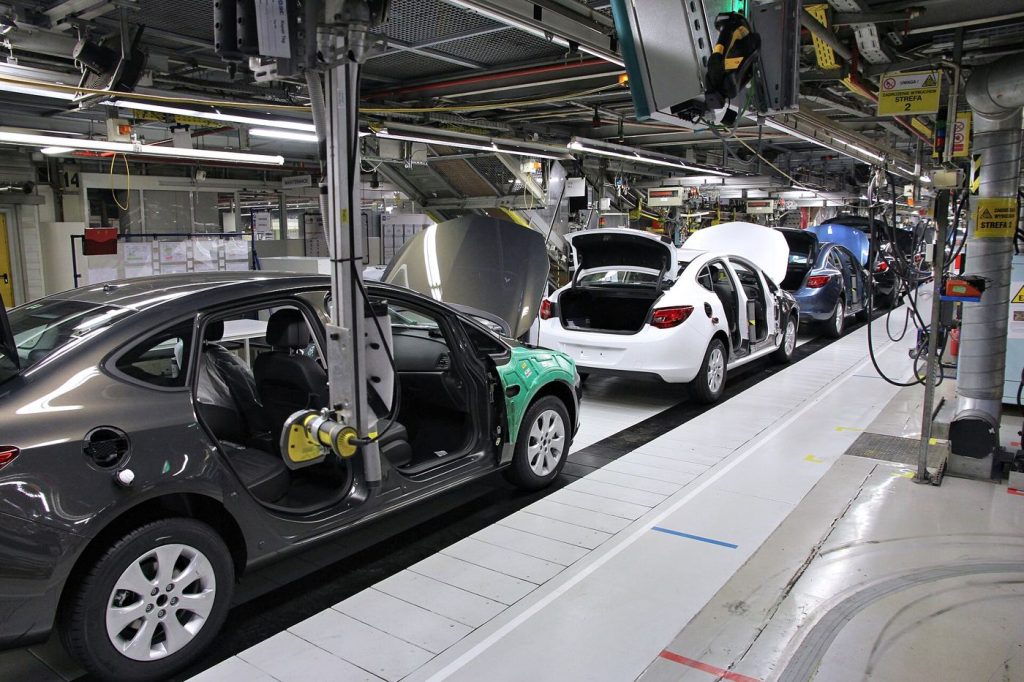 Factory Towns Are Betting on a Manufacturing Comeback Workers on a modern factory assembly line building machinery